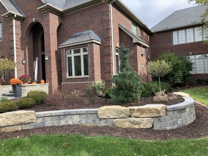 Retaining wall in front of a red brick house 